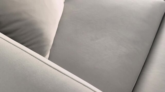 Smartphone with green screen lies on sofa in horizontal position and hand picks it up. Device with chroma display is lifted from couch at home. Concept mobile usage, app mockup, digital