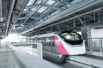 Obraz premium Pink Line Monorail, monorail leave railway station in the capital city. Convenient way of transportation for traveling during rush hour escape from traffic jam