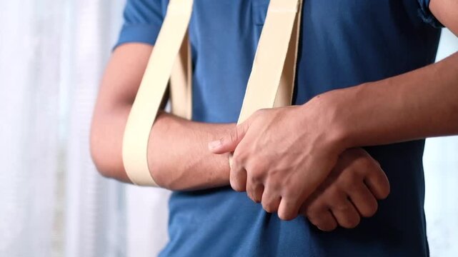 Close up on person arm in sling adjusting bandage for comfort and support