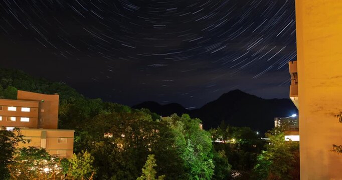 Jozankei Onsen Star Trails Timelapse: Night Sky Astrophotography over Hot Spring Hotels and Mountain Forest, Sapporo, Hokkaido, Japan - Wide Angle Shot