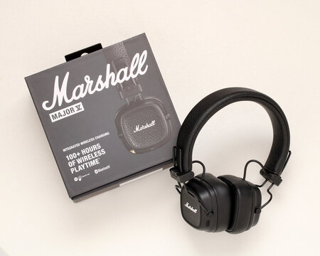 Marshall Major V wireless headphones with retail box on white background. Marshall branded over-ear Bluetooth headphones and original packaging.