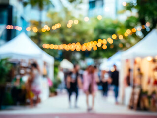 Obraz premium Abstract blurred background with warm bokeh lights and people at a vibrant outdoor market event, festive atmosphere.