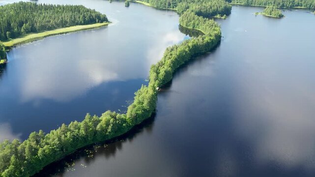 Scenic aerial drone footage of Kyyn&auml;r&auml;nharju ridge in Liesj&auml;rvi National Park, Finland. Calm lake, forest-covered esker, and pristine Nordic wilderness captured from above on a peaceful summer day.
