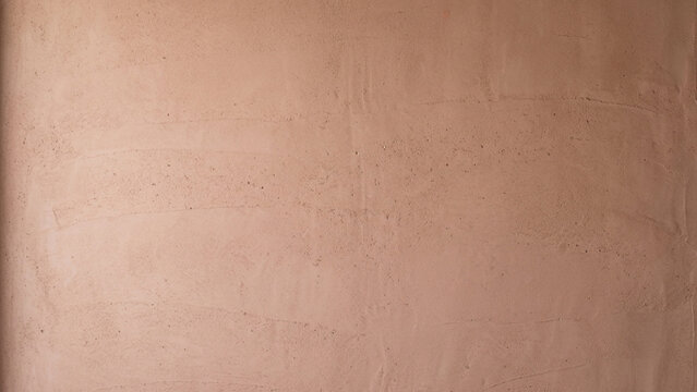 Flat lay of Japanese clay wall texture with soft hand-troweled terracotta plaster for minimalist and organic background.
