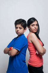 Obraz premium Portrait of sister and brother standing back to back
