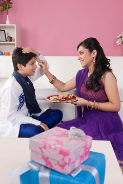 Sister applying tilak to her brother at Raksha Bandhan