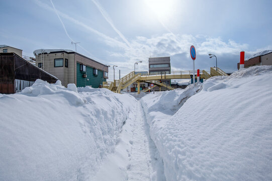 国道に沿った歩道は雪で狭くなっている。国道との間には高い雪の山ができて国道は全く見えない。