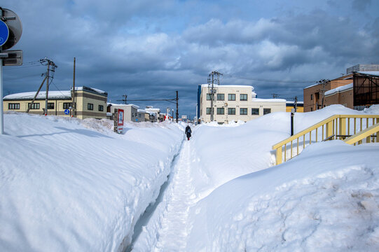 国道に沿った歩道は雪で狭くなっている。国道との間には高い雪の山ができて国道は全く見えない。