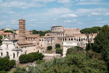 Obraz premium Scenic panoramic view of the historic Roman Forum showing the Basilica of Santa Francesca Romana, the Arch of Titus, and the Colosseum in Rome, Italy
