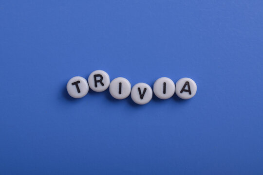 Letter beads spelling Trivia on a blue background, representing quizzes, general knowledge, education, games, learning, and intellectual challenge with copy space.