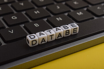 Database spelled with letter beads on a computer keyboard, representing data management, information systems, technology, storage, cybersecurity, and digital infrastructure. © Mulad Images