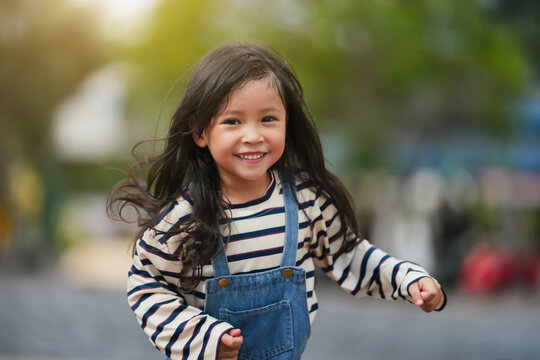 cheerful preschool child girl running in park