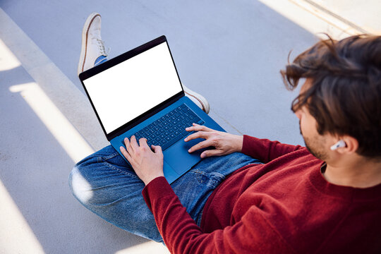 Freelancer using laptop with blank screen outdoors
