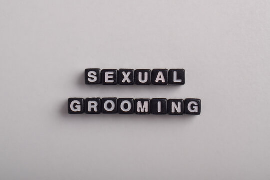 Sexual grooming concept displayed with letter tiles on a white background, highlighting child protection, online safety, abuse prevention, exploitation awareness, and safeguarding education.