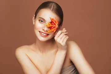 Portrait of beautiful young woman with autumn leafs. Healthy clean fresh skin natural make up beauty eyes © Oleg Gekman