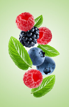 Mix berries with mint leaves on mint background