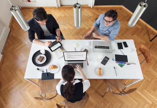Three creative business people having a meeting in a modern office