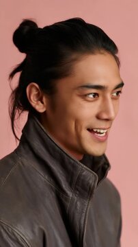 Young man smiling in studio portrait with pink background