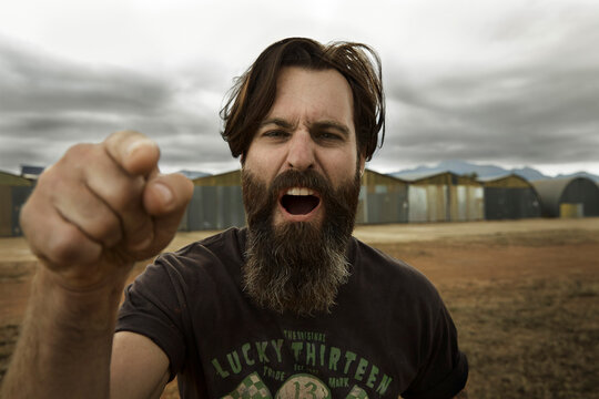 Angry man with full beard shouting at camera