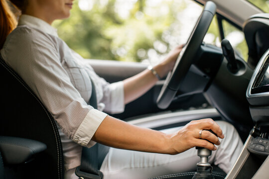 Businesswoman driving car, partial view