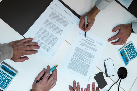 Men analyze a document at the office table