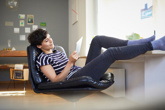Relaxed woman using tablet at home