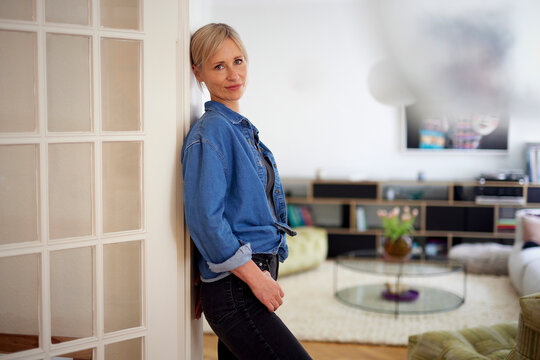 Woman leans against a door in her modern home