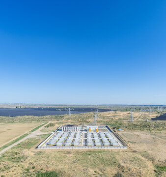 Aerial View of a Grid-Scale Battery Energy Storage Power Station in Semi-Arid Grassland with Solar Farm in Background