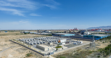 Obraz premium Aerial View of a Grid-Connected Battery Energy Storage Power Station Adjacent to Industrial Complex in Arid Region