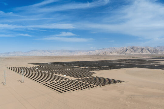 Vast Utility-Scale Solar Photovoltaic Power Plant in Arid Desert Landscape Under Blue Sky