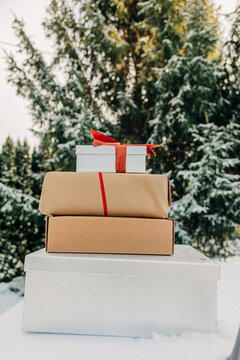 Winter snow covers a stack of Christmas gift boxes outdoors