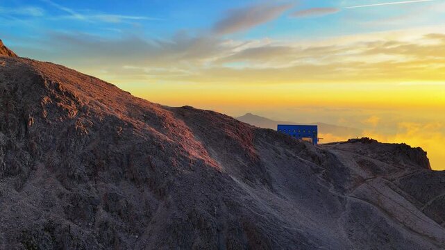 Pan right aerial at sunset overlooking Santner Refuge surrounded by the spectacular Catinaccio mountain range in the Italian Dolomites.