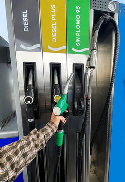 Gasolina, manguera para repostar y surtidor gasolinera cliente self service de combustible di&eacute;sel y sin plomo consumidor en estaci&oacute;n de servicio autoservicio en carretera
