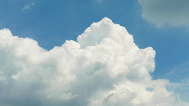 White clouds time lapse. Clouds running across the blue sky. 4k Timelapse of white clouds with blue sky background. Weather concept b roll shot.