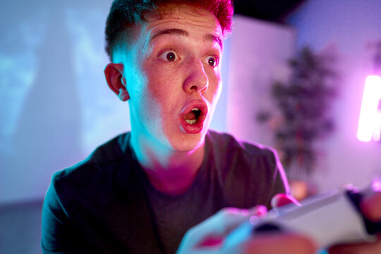 Man with facial expression playing leisure game at home