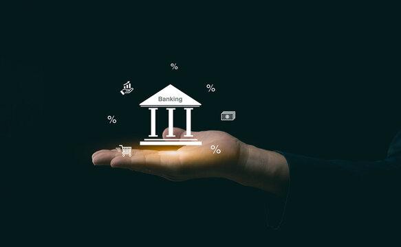 Businessman hand showing glowing bank icon with financial growth and interest percent graphics, concept of online banking and investment stability.