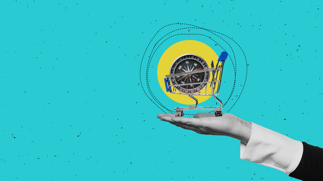 One hand holds shopping cart on blue background