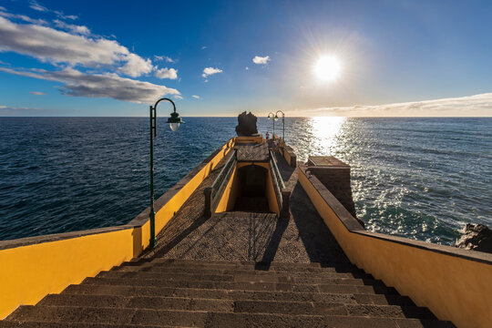 The sun sets over the ocean at Cais da Ponta do Sol in Madeira