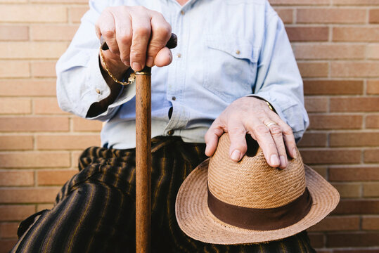 Close-up of old man with cane and straw hat