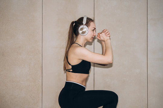 Woman in sportswear performs outdoor squat exercise for fitness