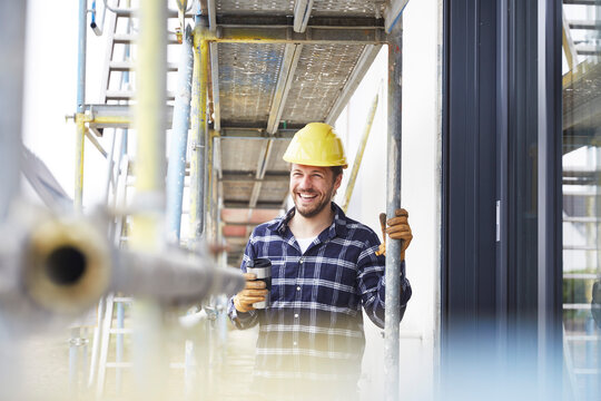 Happy worker having a coffee break on a construction site