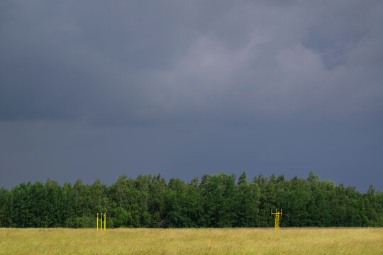 Dark raincloud gathers over runway lights at Eindhoven airport