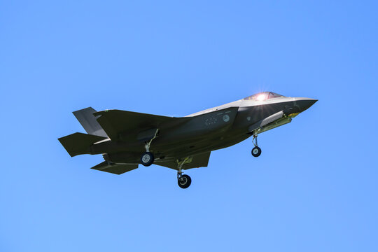 An F-35 stealth fighter jet extends its landing gear in the sky