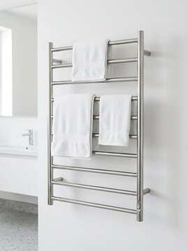 Modern stainless steel heated towel rail mounted on a white wall