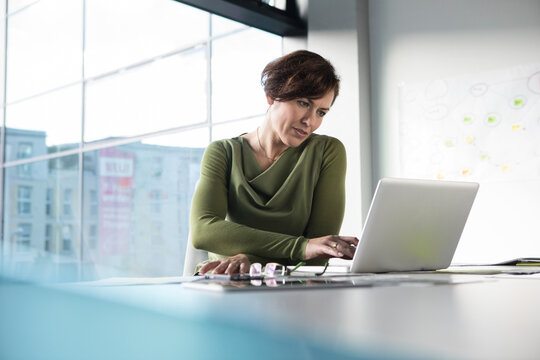 Businesswoman using laptop in office