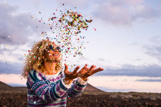 Happy blond woman throwing confetti in the air, Tenerife, Spain