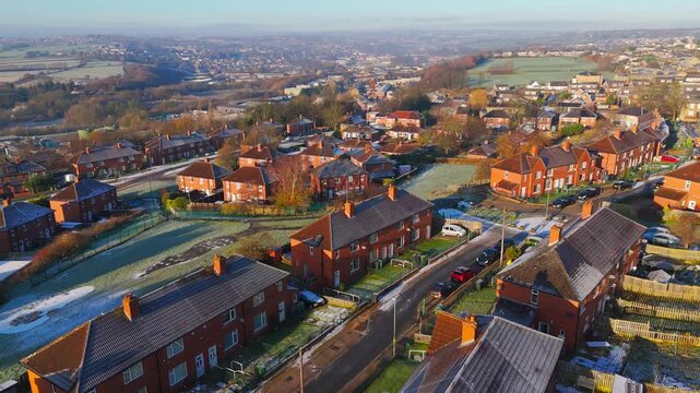 Drone's-eye winter view captures Dewsbury Moore Council estate's typical UK urban council-owned housing development with red-brick terraced homes and the industrial Yorkshire. Working class housing