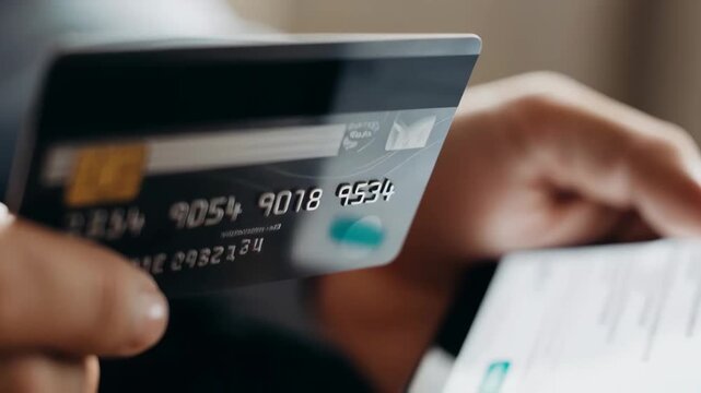 Person holding a credit card and smartphone making a mobile payment and online purchase. closeup sequence shows hand entering card details in a payment app.