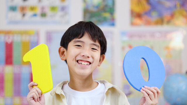 Happy Asian Boy Holding Large Number Ten Foam Cutouts in Classroom