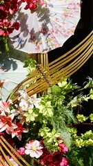 Fototapeta premium Chinese umbrellas and flowers hanging on the wall